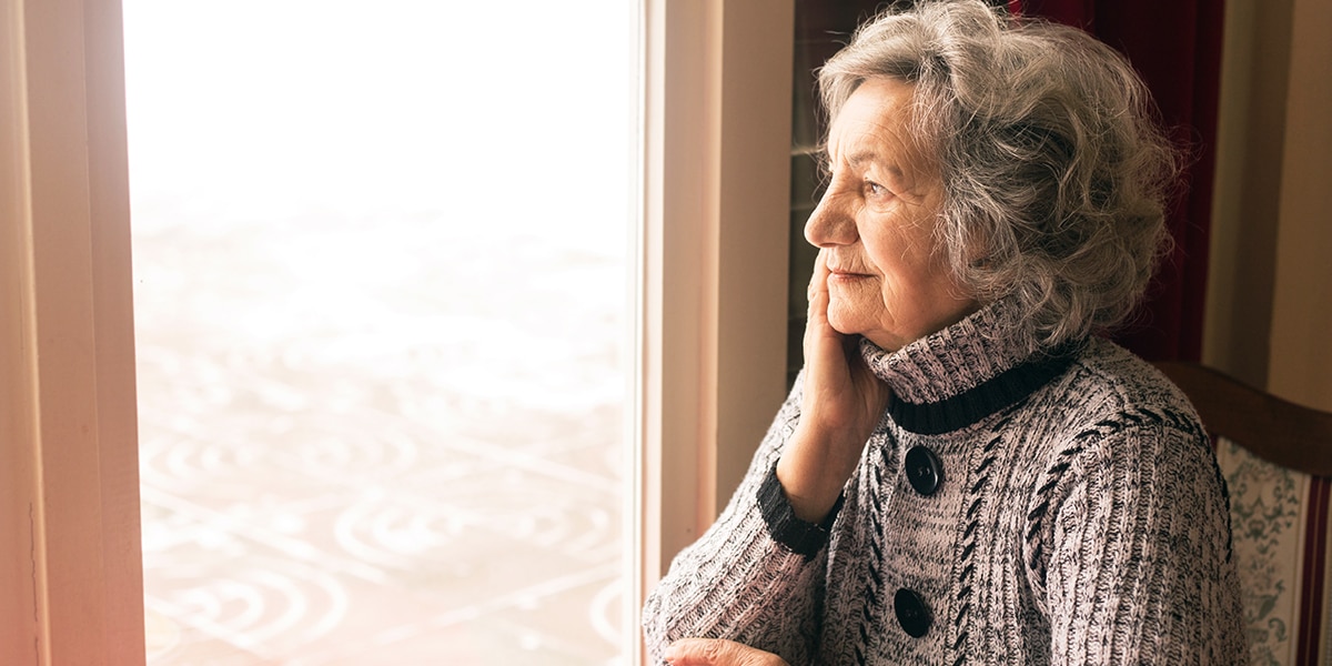 Elderly woman looking out of the window