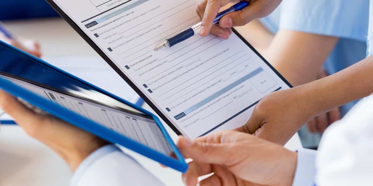 doctor and patient filling out a form