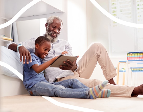 Grandfather with Grandson and Tablet Improve Care for Seniors and the Vulnerable